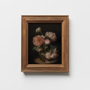 May include: A framed still life painting featuring a bouquet of pink roses in a clear vase. The roses have multiple layers of petals and are set against a dark background. The frame is a warm, textured brown.