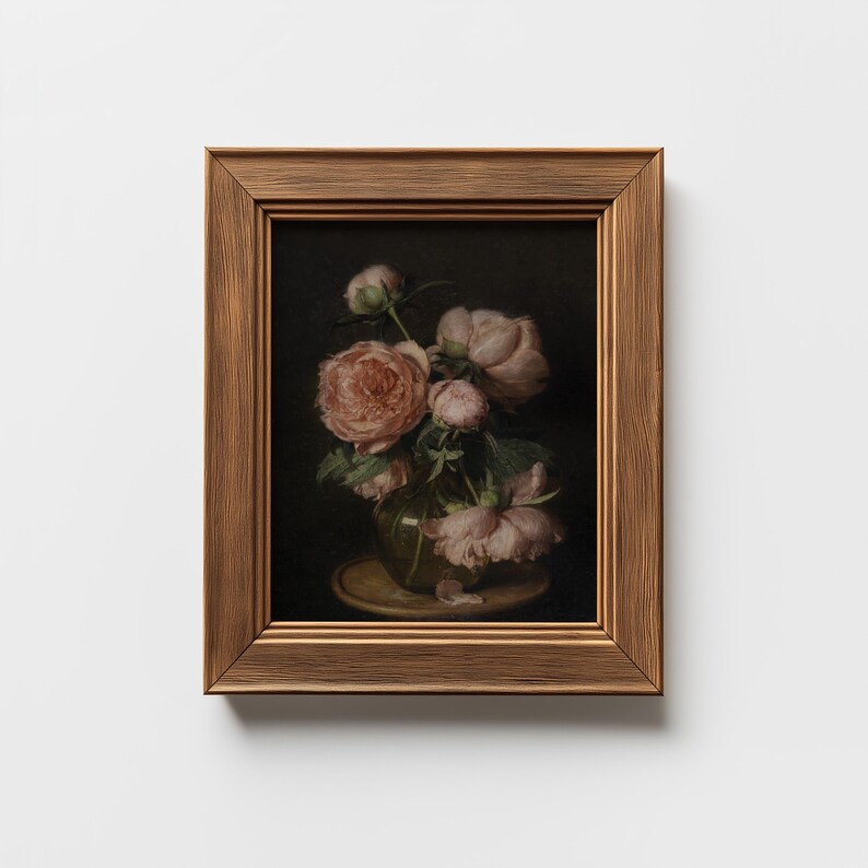 May include: A framed still life painting featuring a bouquet of pink roses in a clear vase. The roses have multiple layers of petals and are set against a dark background. The frame is a warm, textured brown.