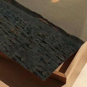 May include: An oil painting depicting a seascape with dark blue water and a muted gray sky. The artwork is framed in a natural wood frame, with the canvas slightly angled, revealing the texture of the paint.