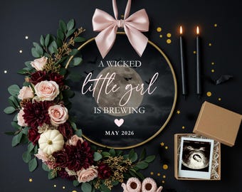 May include: A Halloween-themed pregnancy announcement with a gold hoop adorned with flowers, a pink bow, and the text "A wicked little girl is brewing." Includes baby booties, candles, and an ultrasound image.