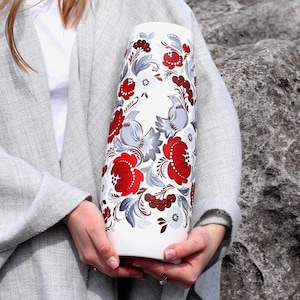 May include: White ceramic vase with a hand-painted design featuring red and gray flowers, birds, and berries.
