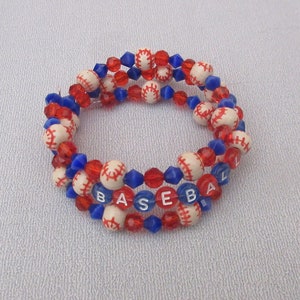 May include: A multi-strand bracelet made with white baseball beads, red and blue glass beads, and letter beads spelling out "BASEBALL".