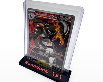 Könnte beinhalten: Eine Team Rocket's Houndoom Sammelkarte mit 130 KP befindet sich in einer durchsichtigen Kunststoffhülle. Die Karte wird von einem schwarzen rechteckigen Ständer gehalten, der vorne den roten Schriftzug Houndoom 191 trägt.
