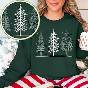Può includere: Una felpa verde scuro con una grafica bianca di tre alberi di Natale. Gli alberi hanno stelle in cima e sono decorati con testo. La felpa è abbinata a pantaloni del pigiama a righe rosse e bianche.