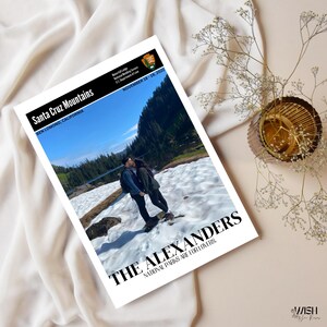 May include: A printed photograph featuring the Santa Cruz Mountains and the text "THE ALEXANDERS NATIONAL PARKS ARE FOR LOVERS." The image includes a couple in a snowy landscape. The text "BEN LOMOND, CALIFORNIA" and "NOVEMBER 18-19, 2022" are also visible.