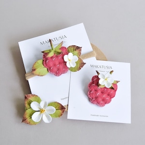 Puede incluir: Accesorios de fieltro hechos a mano con diseño de frambuesa. El conjunto incluye una diadema, una pinza para el pelo y una flor separada. La frambuesa es roja con hojas verdes y una flor blanca. Las tarjetas dicen "MAKATUSIA Felt Flowers."