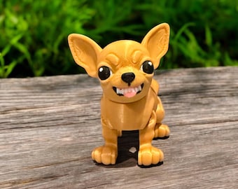 May include: A 3D printed figurine of a chihuahua dog with a brown and tan color scheme. The dog is standing on a wooden surface and has a playful expression on its face.