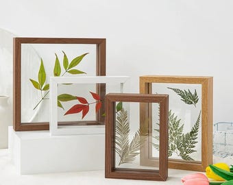 Könnte beinhalten: Vier verschiedene Bilderrahmen in verschiedenen Größen mit Holzrahmen und klarem Glas. Die Rahmen sind leer und bereit, um gepresste Blumen oder andere kleine Gegenstände zu präsentieren.