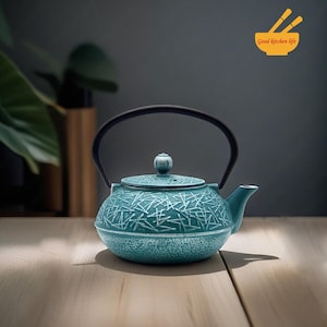 May include: A teal blue cast iron teapot with a black handle and a white geometric pattern. The teapot has a small knob on the lid.