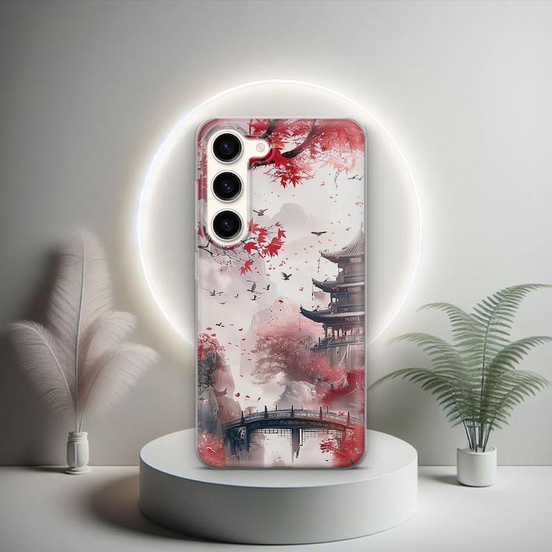 Puede incluir: Una funda de tel&eacute;fono con un dise&ntilde;o de una pagoda japonesa, un puente y hojas de arce rojas en un estilo de acuarela.