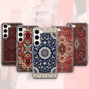 Puede incluir: Cinco fundas para teléfono con intrincados diseños de alfombras. Las fundas presentan patrones en tonos de rojo, azul y crema. Cada funda tiene un diseño diferente, mostrando una variedad de motivos de alfombras tradicionales. Las fundas están diseñadas para un smartphone.