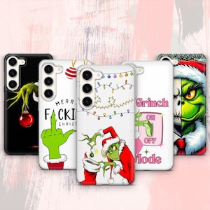 Puede incluir: Una colección de cinco fundas para teléfono con diseños del Grinch. Las fundas presentan al Grinch en varias poses, con texto como "Merry F*cking Christmas" y "Grinch ON/OFF Mode". Las fundas son en blanco y negro, con acentos verdes, rojos y blancos.