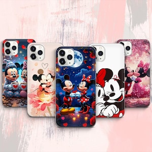 Puede incluir: Una colección de fundas para teléfonos con Mickey y Minnie Mouse de Disney. Las fundas muestran varias escenas románticas, incluyendo a Mickey y Minnie tomados de la mano bajo un cielo iluminado por la luna, y una escena invernal. Las fundas tienen un acabado brillante.