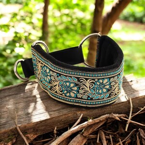 Puede incluir: Un collar de perro negro con un patr&oacute;n floral turquesa y dorado. El collar est&aacute; acolchado y tiene dos anillos en D plateados.