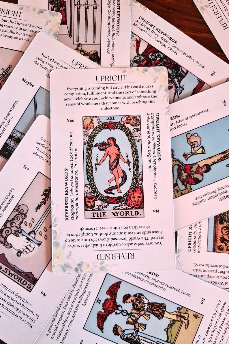 May include: The World tarot card with a pink background and white text. The card depicts a woman standing inside a wreath with a lion and an eagle. The text on the card reads "The World". The card's keywords are listed below the image. The keywords for the upright card are: Completion, Fulfillment, Wholeness, Success. The keywords for the reversed card are: Stagnation, Delayed success, Lack of closure, Incompletion, Resistance, Frustration.