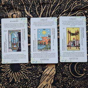 May include: Three tarot cards with illustrations and text. The cards are titled "The High Priestess", "The Star", and "The Emperor". The cards are from a tarot deck.