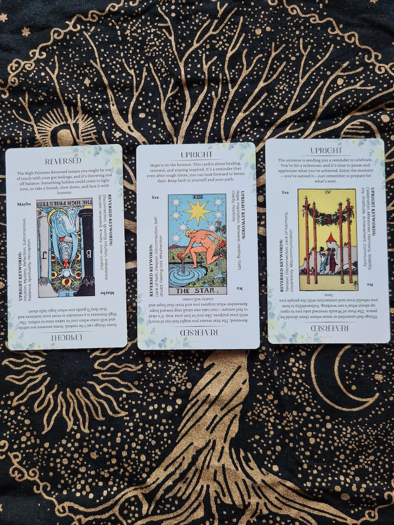 May include: Three tarot cards with illustrations and text. The cards are titled "The High Priestess", "The Star", and "The Emperor". The cards are from a tarot deck.