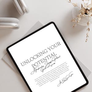 Könnte beinhalten: Ein weißes Tablet mit einem schwarzen Bildschirm, auf dem ein Textdokument mit dem Titel "Unlocking Your Potential: A Transformative Journey to Personal Growth and Success" angezeigt wird. Der Text ist in Schwarzweiß und der Hintergrund ist weiß. Das Tablet befindet sich auf einer weißen Oberfläche.