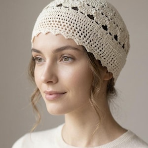 Peut inclure: Un chapeau en crochet de couleur crème avec un bord festonné. Le chapeau présente un motif ajouré avec des découpes en forme de cœur. Fabriqué en fil léger, il est idéal pour les journées chaudes.