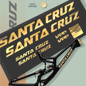 Może przedstawiać: Czarna rama roweru Santa Cruz ze złotymi chromowanymi literami i akcentami. Obraz zawiera wiele złotych naklejek Santa Cruz oraz tekst "GOLD CHROME" i "MAX MODEL STUDIO".