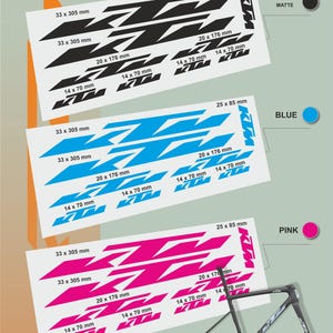 May include: Sheets of KTM motorcycle decals in black, blue, and pink. Each sheet features various sizes of the KTM logo, with dimensions such as 33 x 305 mm and 20 x 176 mm. A bicycle frame is also shown.
