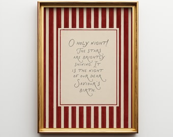 May include: A framed print with a gold-colored frame. The print features a cream-colored center with the text "O Holy Night!" in elegant script. The background has red and white vertical stripes, creating a festive holiday theme.