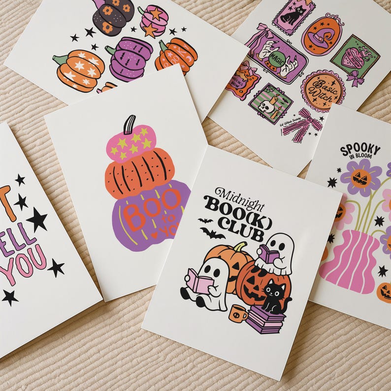 May include: A collection of Halloween-themed greeting cards featuring colorful illustrations. Designs include pumpkins, ghosts, cats, and the text "Midnight BOO(k) Club" and "Spooky in Bloom". The cards are on a neutral background.