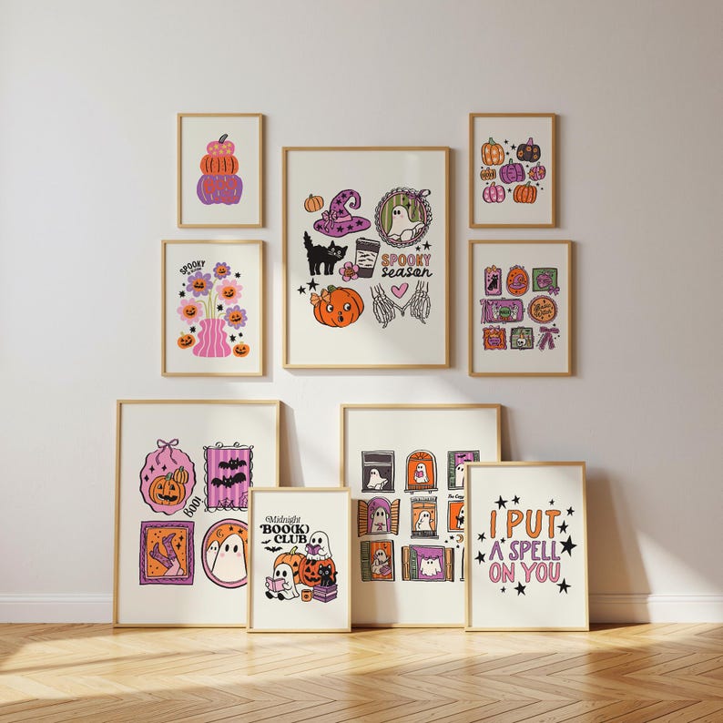 May include: A collection of framed Halloween-themed art prints. The prints feature illustrations of pumpkins, ghosts, witch hats, and the text "Spooky Season", "Boo(k) Club", and "I Put a Spell on You". The color palette includes orange, purple, and black.