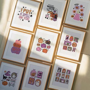 May include: A collection of framed Halloween-themed art prints. The prints feature various designs, including pumpkins, ghosts, and the text "I PUT A SPELL ON YOU" and "Midnight BOO(K) CLUB". The color palette includes orange, purple, and black.