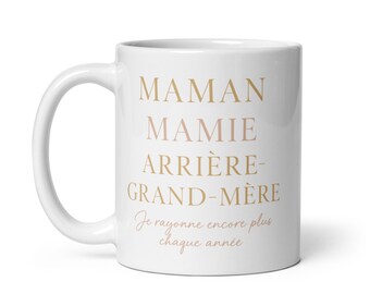 May include: White ceramic mug with the text "Maman Mamie Arrière-Grand-Mère" in gold lettering and the text "Je rayonne encore plus chaque année" in pink lettering.