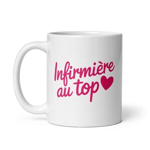 May include: White ceramic mug with a pink design that says "Infirmière au top" with a pink heart.