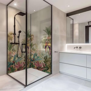 May include: A modern bathroom with a walk-in shower featuring a tropical print with parrots and palm trees. The shower has a black frame and a black shower head. The bathroom also has a white vanity with two drawers and a white countertop with a sink and two black faucets.