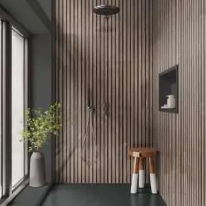 May include: A contemporary shower room featuring a slatted wooden wall and a dark grey floor. A small wooden stool with white-painted legs is positioned near the showerhead. A tall grey vase with foliage stands by a large window.