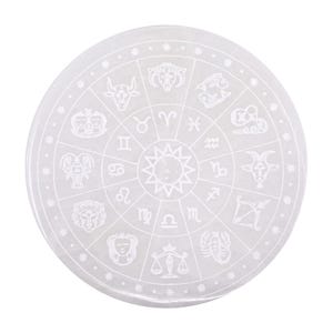 Könnte beinhalten: Eine runde, weiße Selenit-Kristall-Ladeplatte. Die Platte zeigt ein geätztes Design der Tierkreiszeichen, die kreisförmig um einen zentralen Sonnenstrahl angeordnet sind. Ein spirituelles und dekoratives Objekt.