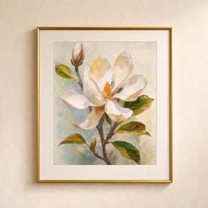 May include: A framed floral art print featuring a large white magnolia flower in full bloom, with a bud and green leaves. The painting has a soft, impressionistic style, set against a light blue and green background, framed in gold.