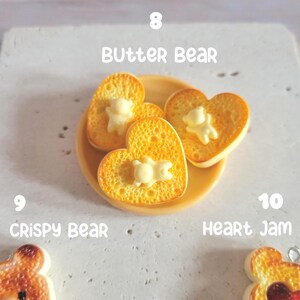 Puede incluir: Primer plano de un plato amarillo con tres tostadas en forma de coraz&oacute;n, cada una cubierta con una porci&oacute;n de mantequilla blanca con forma de oso. El texto "BUTTER BEAR" est&aacute; encima del plato.