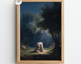 May include: A framed print of a religious scene. The artwork depicts a figure kneeling in a white robe under a tree, bathed in light. The background features a dark, forested area with a blue sky. The frame is made of light-colored wood.