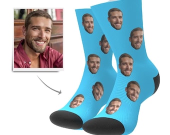 Könnte beinhalten: Ein Paar blaue Socken mit einem sich wiederholenden Muster eines Gesichts. Die Socken sind aus einem weichen, bequemen Material gefertigt und perfekt für den Alltag.