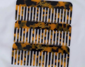 May include: Three tortoiseshell combs with gold lettering. The top comb says "Katie", the middle comb says "Taylor", and the bottom comb says "Ying".