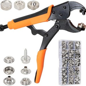 May include: A black and orange snap fastener tool with various metal snap components and a clear plastic container filled with silver snaps. The tool has an orange handle and is designed for applying snaps to fabric or other materials.