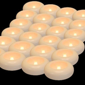 May include: A collection of ivory-colored, battery-operated LED tea light candles. Each candle has a warm, flickering light, creating a soft, inviting glow. The candles are arranged in a diagonal pattern against a black background.