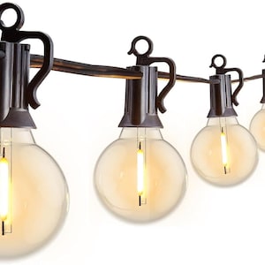 May include: String of outdoor globe lights with warm, yellow illumination. Each bulb is round and clear, suspended from a dark brown wire with decorative metal fixtures. The lights are ideal for patios and outdoor spaces.