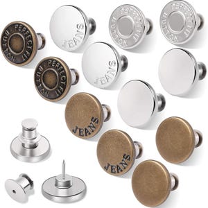 May include: Assortment of metal jeans buttons in silver and brass finishes. The buttons feature the words "Perfect Fit" and "Jeans".