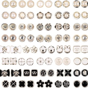 May include: A collection of various stud earrings in gold, silver, and black. The earrings feature designs such as pearls, crystals, flowers, bows, stars, and geometric shapes. The earrings are arranged in rows and columns.
