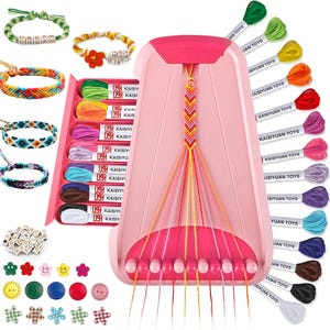 May include: A pink friendship bracelet making kit with colourful embroidery floss, beads, and buttons. The kit includes a pink loom, spools of thread, and several finished bracelets in various colours and patterns.
