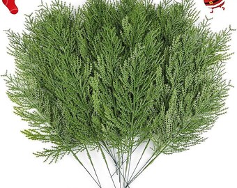May include: A collection of artificial green fern stems with slender, dark stems. The fern fronds are a vivid green, and the stems are arranged in a fan shape. Festive holiday decorations are in the background.
