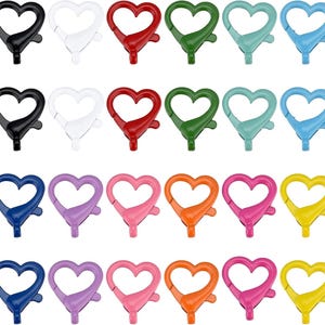 May include: A collection of heart-shaped swivel clasps in various colors, including black, white, red, green, blue, purple, pink, orange, and yellow. These clasps are designed for attaching to keychains, lanyards, or other accessories.