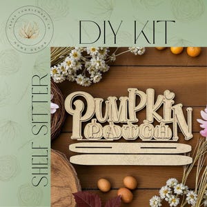 May include: A wooden DIY kit for a shelf sitter, featuring the words "Pumpkin Patch" in a decorative font. The kit includes the letters, pumpkins, and a base for display. The background includes flowers and small pumpkins.