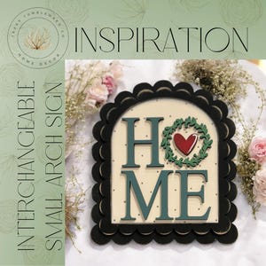 May include: A small, interchangeable arch sign with the word "HOME" in teal letters. The "O" is replaced with a wreath and heart design. The sign is framed with a black scalloped edge and the text "INSPIRATION" is at the top.
