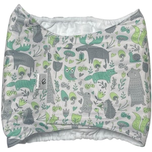 May include: A white cloth diaper cover with a whimsical forest animal print in gray and teal. The design includes moose, foxes, owls, and mushrooms. The interior is white and fluffy.